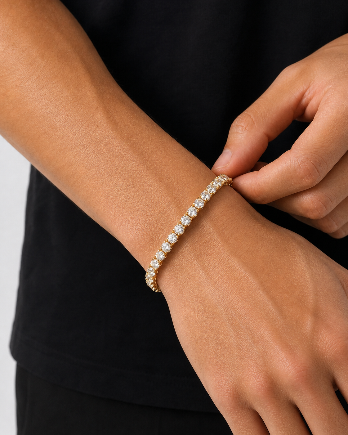 Gold Iced Tennis Bracelet 5 mm worn on a male model while adjusting the fit
