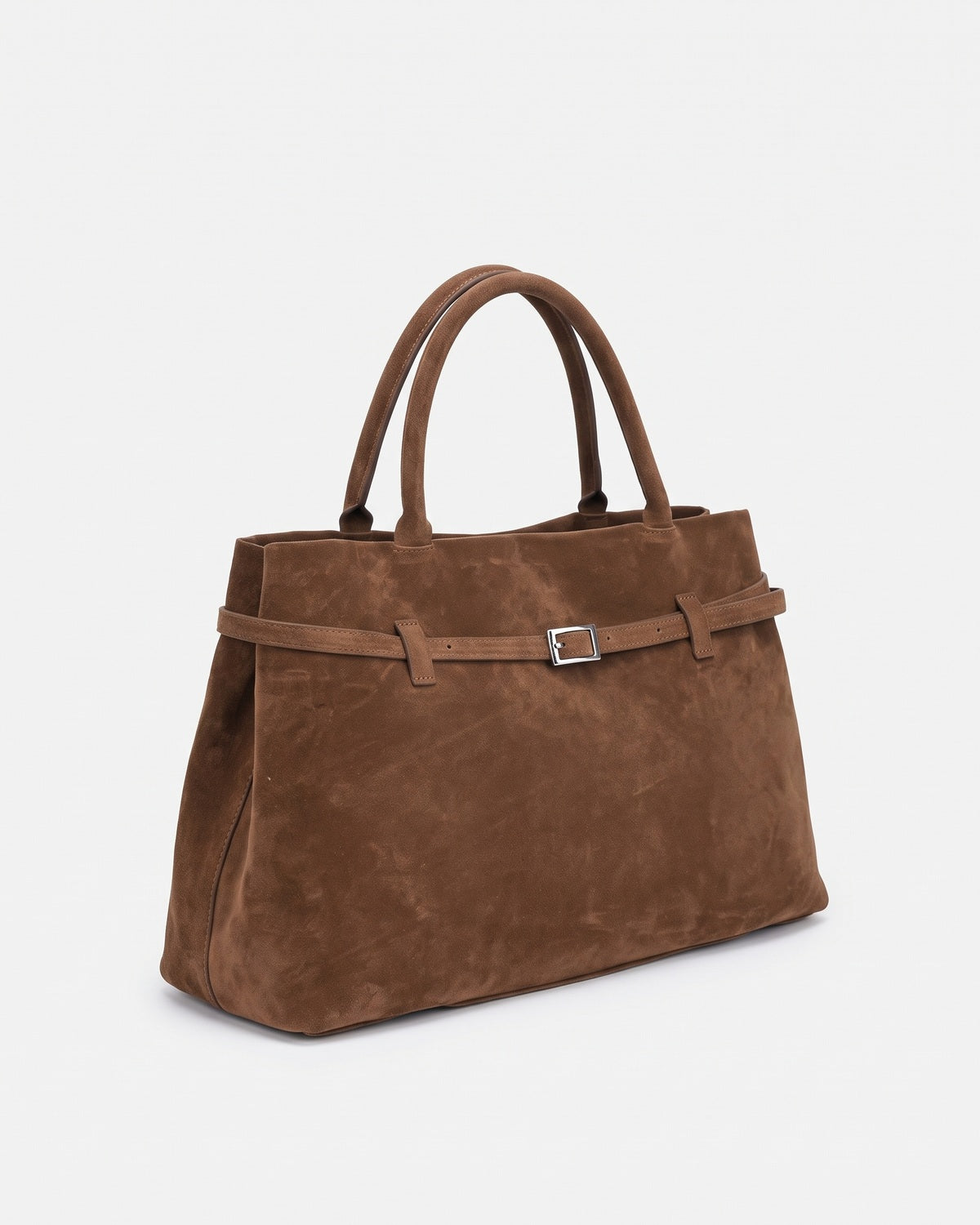 Chocolate brown suede top handle bag with a slim belted front and square buckle, three-quarter view on a plain background