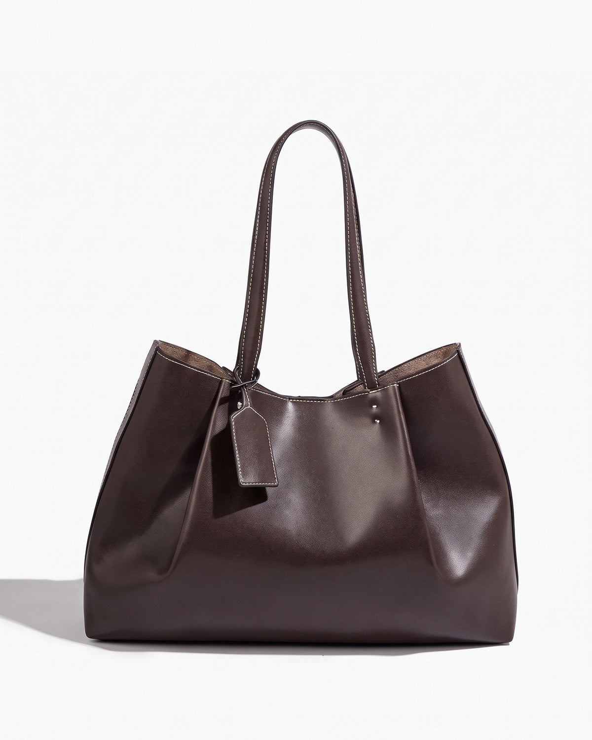 Brown soft tote bag with contrast topstitching and twin handles, on a plain background