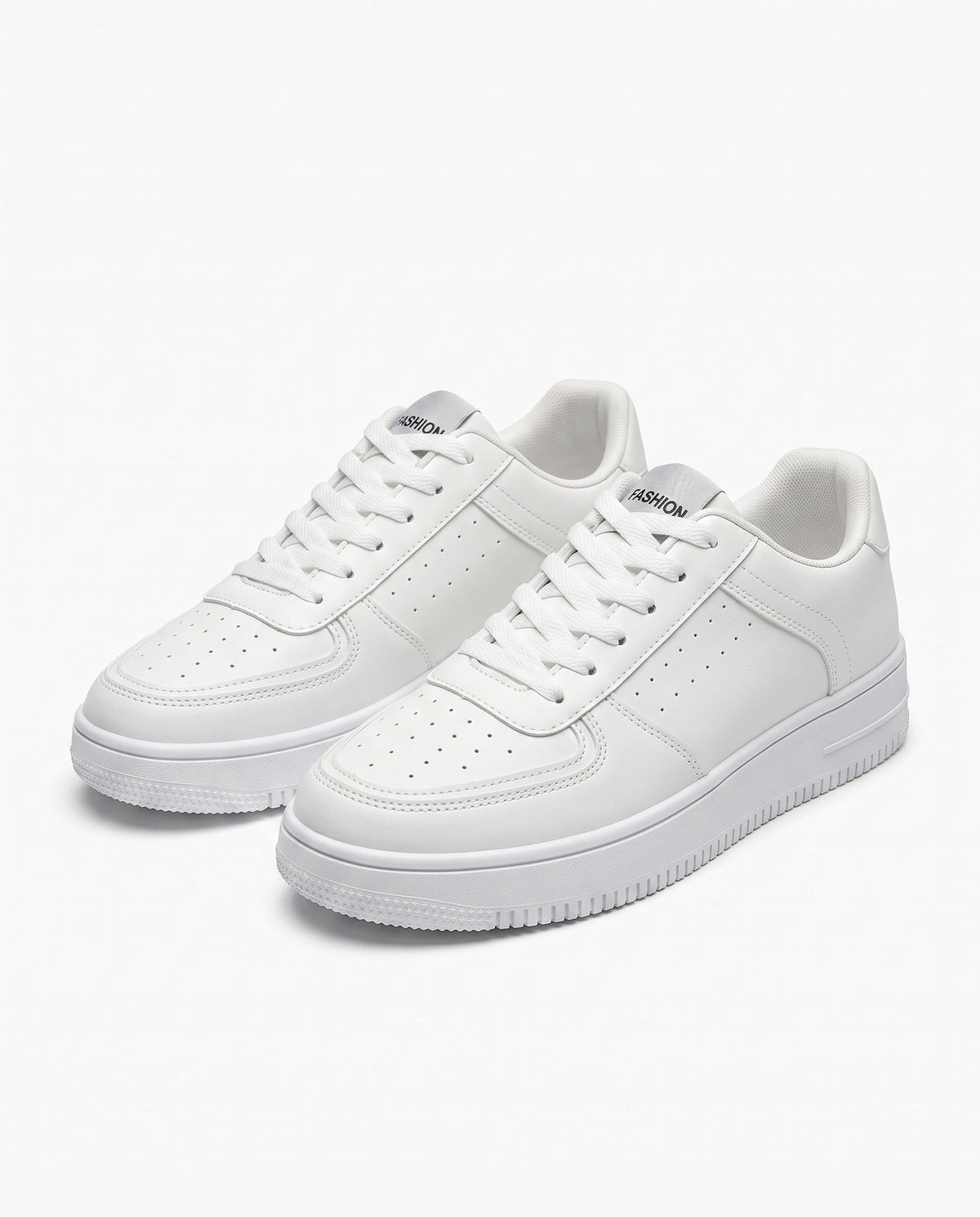 White low top sneaker with perforated toe and side panels on a thick moulded sole, studio product shot