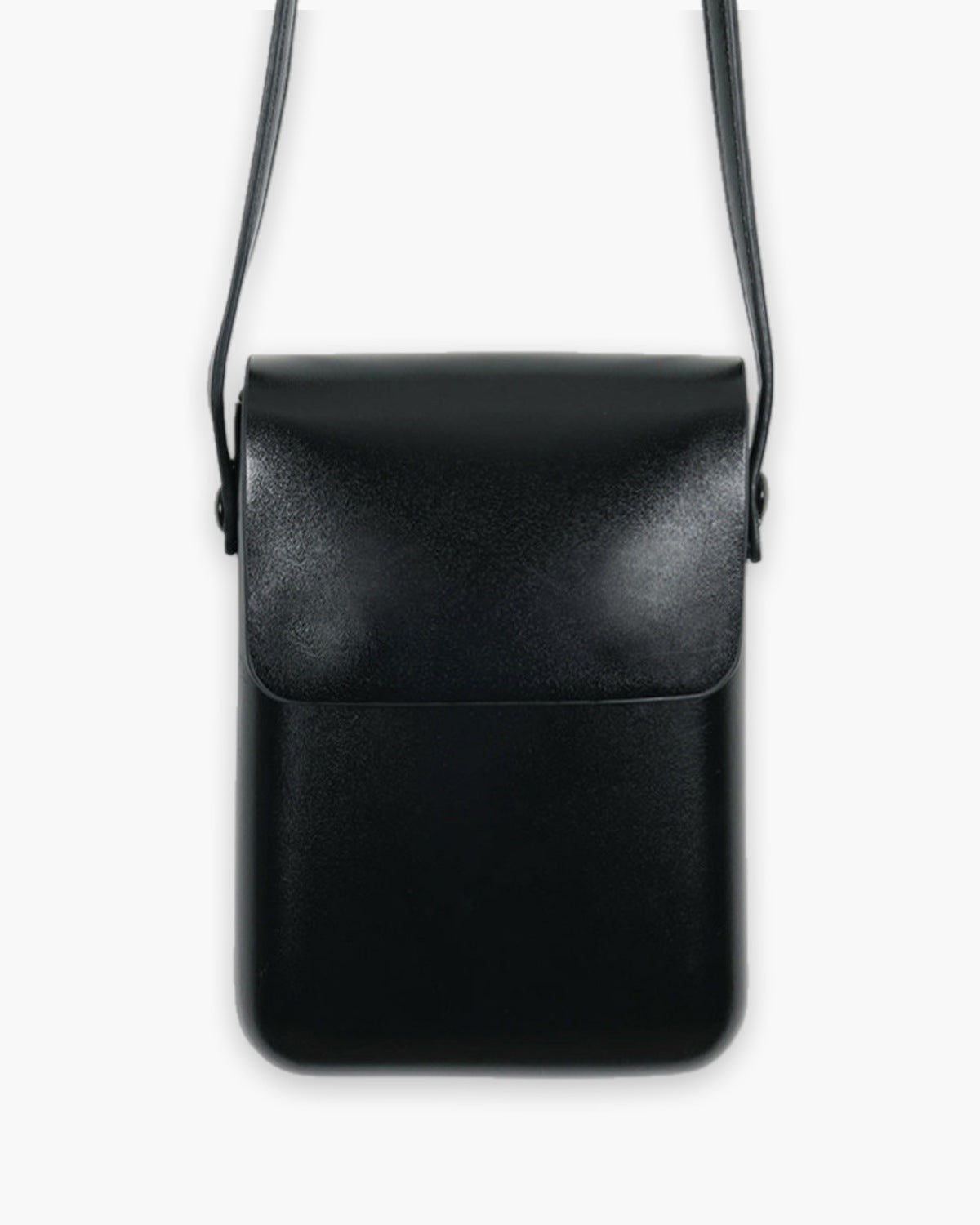 Black mini crossbody bag with a short front flap, on a plain background