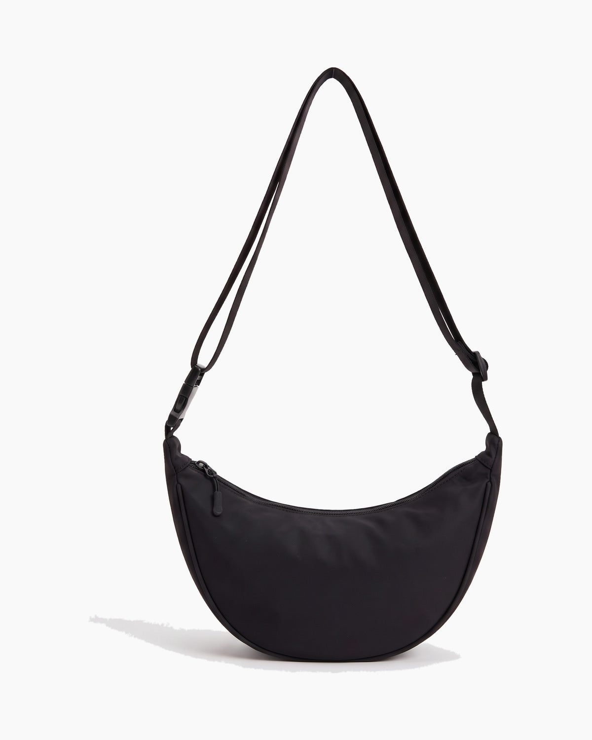 Black sling bag with a crescent body and a single top zip, on a plain background