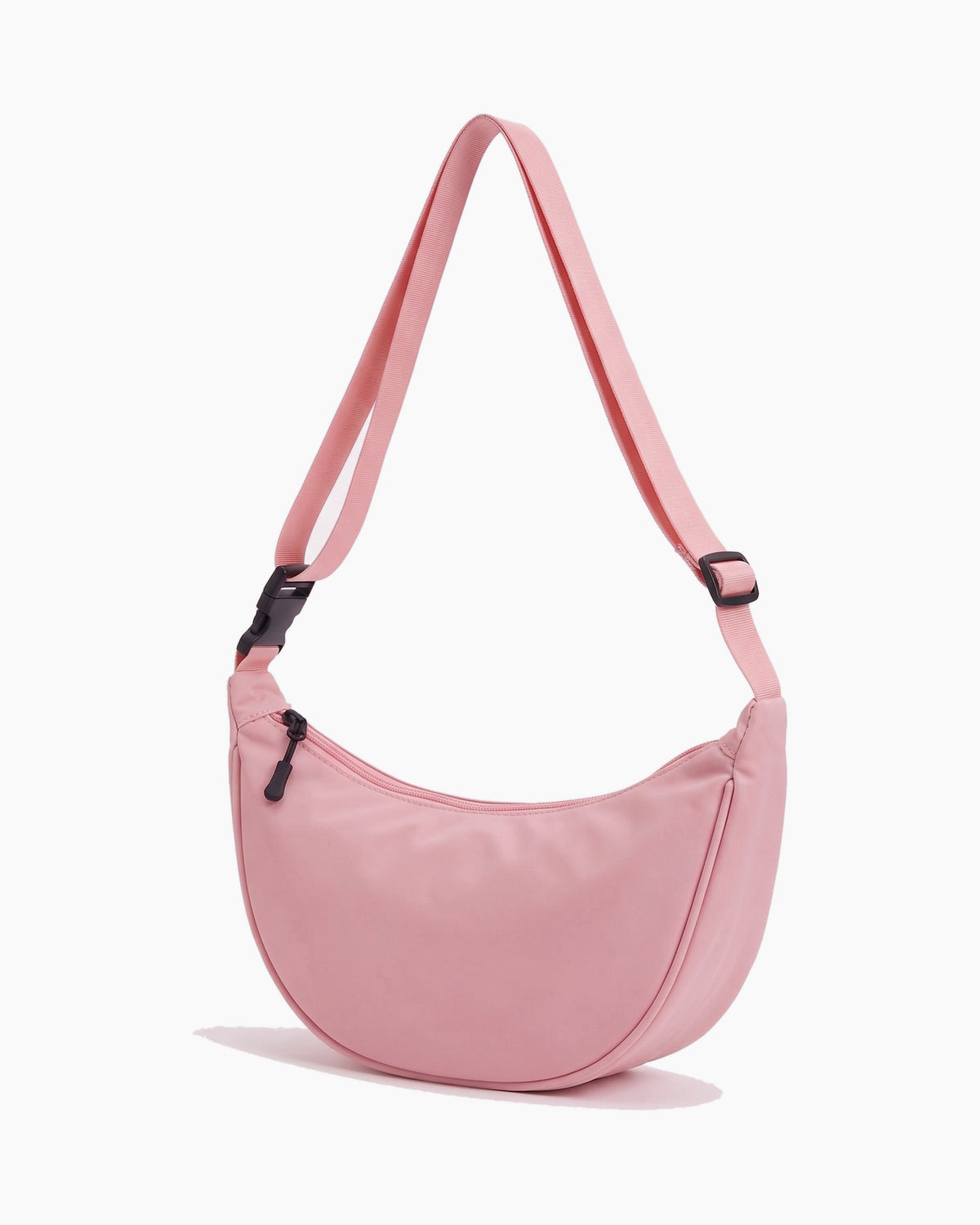 Pink sling bag turned to show its depth and side, on a plain background