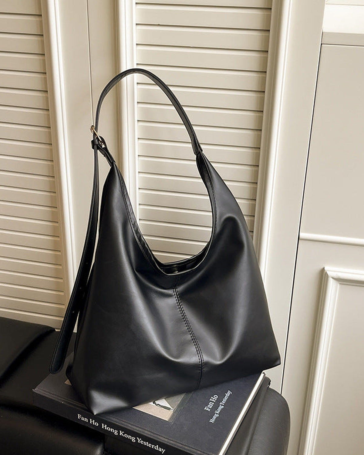 Black slouchy shoulder bag standing upright, front view