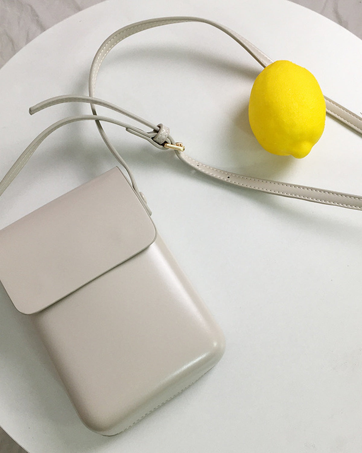 Off-white mini crossbody bag styled on a table