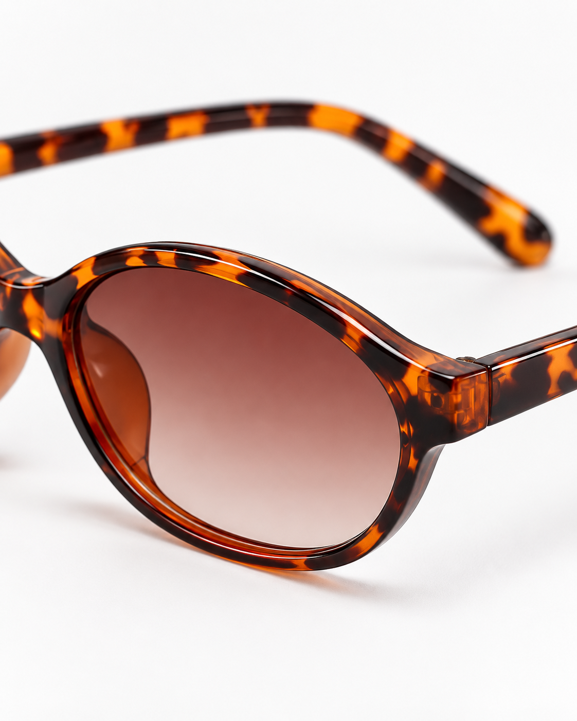 Oval Sunglasses in tortoiseshell with brown gradient lenses, close up of the frame