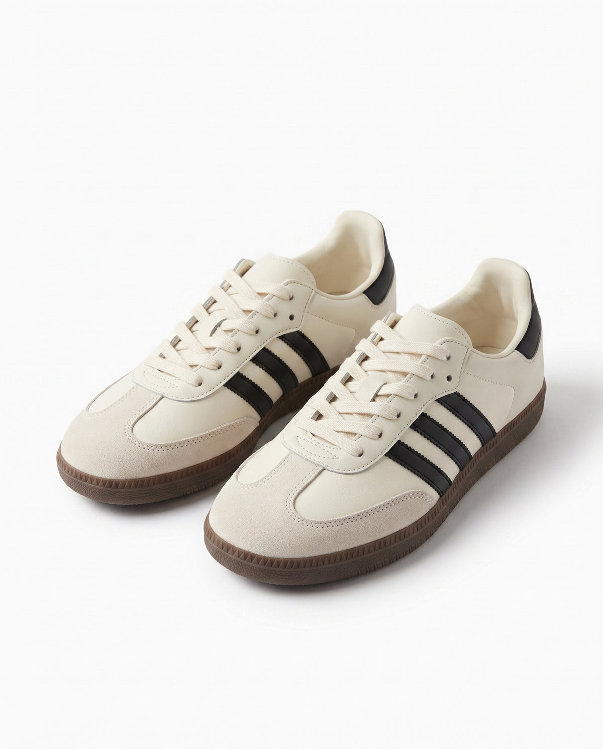 Cream retro low top sneaker with three black side stripes, cream suede toe and brown gum sole, studio product shot