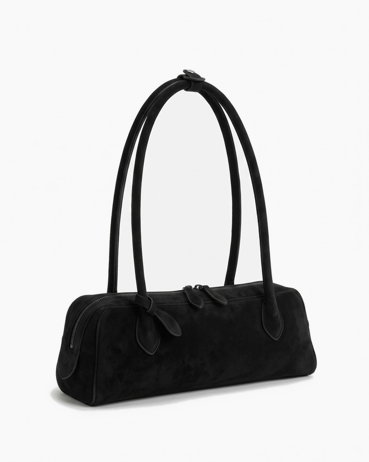 Black suede baguette bag with knotted end tabs, three-quarter view on a plain background