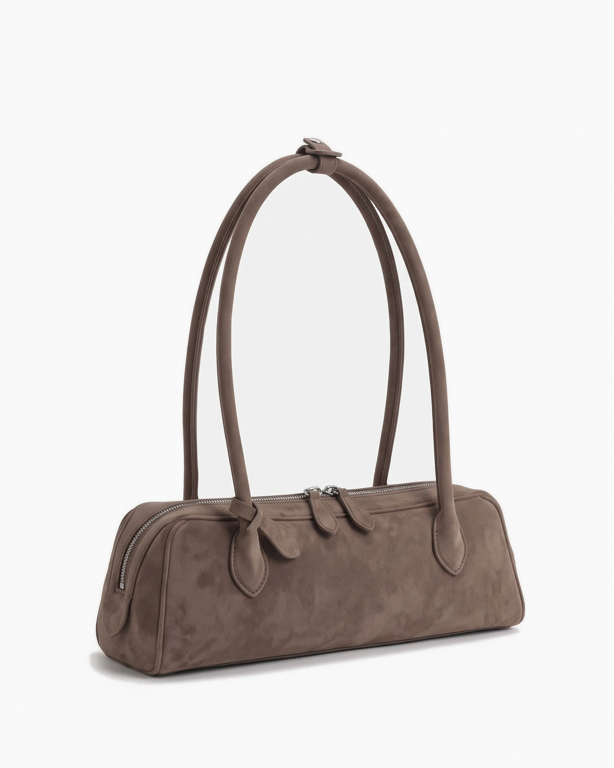 Taupe suede baguette bag with knotted end tabs, three-quarter view on a plain background